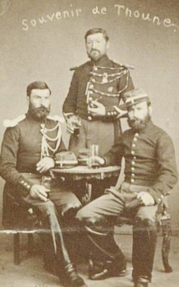 Photographie de trois hommes en tenue militaire. 